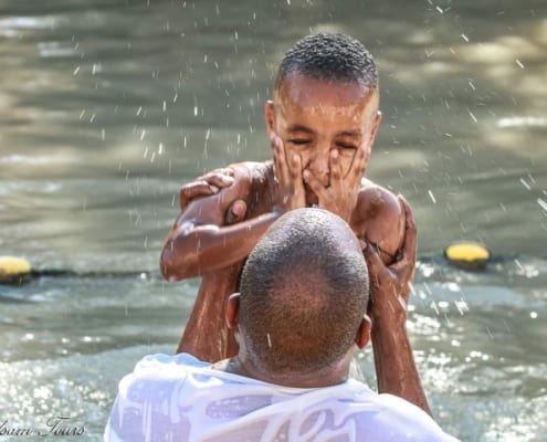 Boy getting baptized in the Jordan River | Balsam Tours